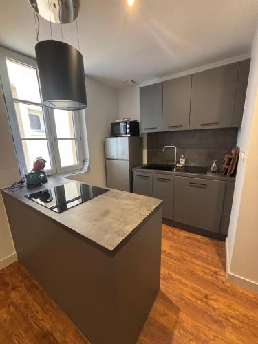 une cuisine avec un grand îlot au milieu dans l'établissement le Prestige de Béziers, à Béziers