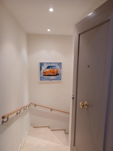 un couloir avec une peinture d'une voiture sur le mur dans l'établissement Joli 2 pièces en bord de mer, à Théoule-sur-Mer