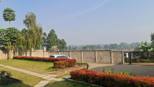 a car parked in a driveway next to a fence at Sydney-Bali Sanctuary in Fort Portal