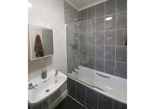a bathroom with a tub and a sink and a bath tub at College House in Crawley