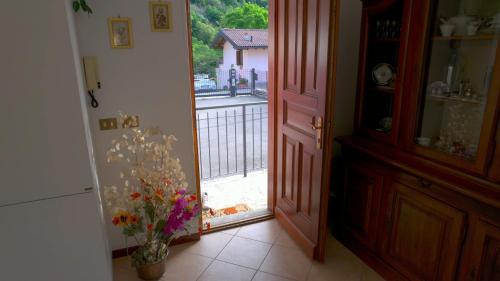a hallway with an open door with a vase of flowers at Giò Giò House - Lake Como in Muronico