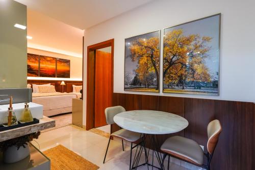 a living room with a table and a bedroom at Ananda Pousada in Pirenópolis