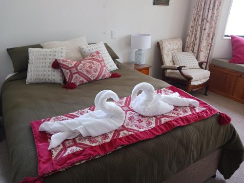 two swans towels on a bed in a bedroom at Doonside Private Cottage at Grossi Point Reserve in Mapua