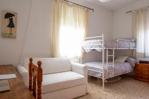 un soggiorno con divano e letto a castello di La Platea Rural a Siviglia