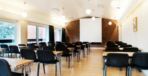 an empty classroom with tables and chairs and a whiteboard at Oscarsborg Castle Hotel & Resort in Drøbak