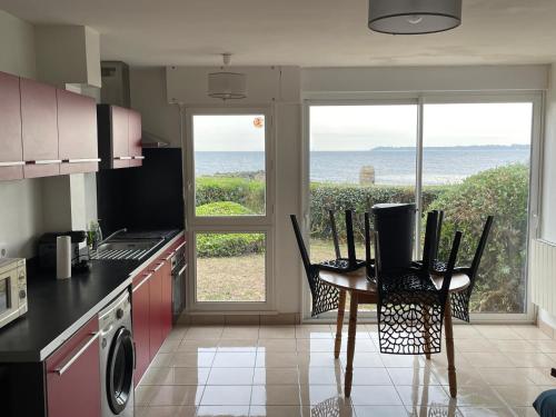 cocina con mesa y sillas y vistas al océano en T2 37 M2 les pieds dans l'eau, en Ploemeur