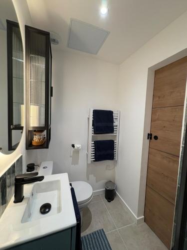 une salle de bain blanche avec un lavabo et des toilettes dans l'établissement Maison Lazuli, à La Calmette