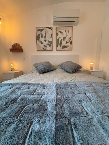 une chambre avec un grand lit avec deux oreillers dessus dans l'établissement Maison Lazuli, à La Calmette