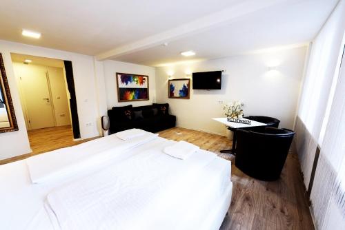 a bedroom with a large bed and a living room at MoselUnion - Haus Burg Chaussee in Cochem