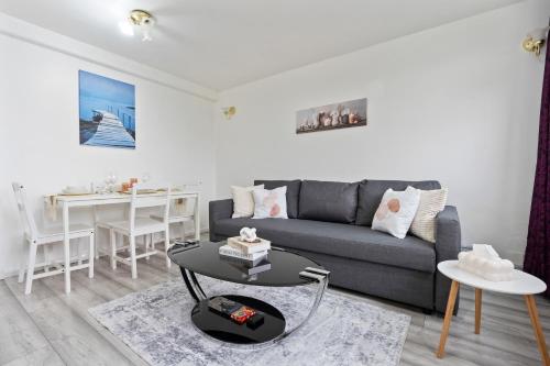 a living room with a couch and a table at Modern 1-Bedroom Stockwell Apartment 15 mins to Central London - Perfect Base for Exploring London in London