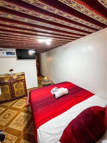 a bedroom with a red and white bed in a room at Riad Dar El Ouedghiri in Fès