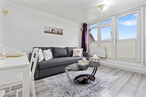 a living room with a couch and a table at Modern 1-Bedroom Stockwell Apartment 15 mins to Central London - Perfect Base for Exploring London in London