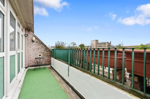 a balcony with green flooring on a building at Modern 1-Bedroom Stockwell Apartment 15 mins to Central London - Perfect Base for Exploring London in London