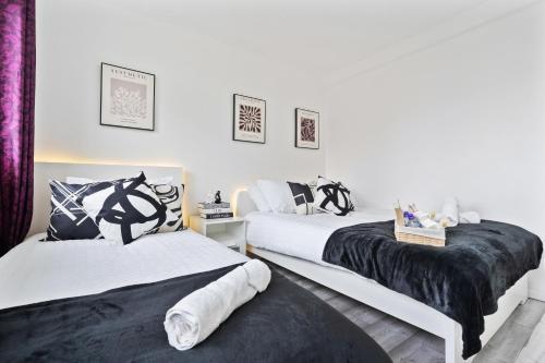 two beds sitting next to each other in a bedroom at Modern 1-Bedroom Stockwell Apartment 15 mins to Central London - Perfect Base for Exploring London in London