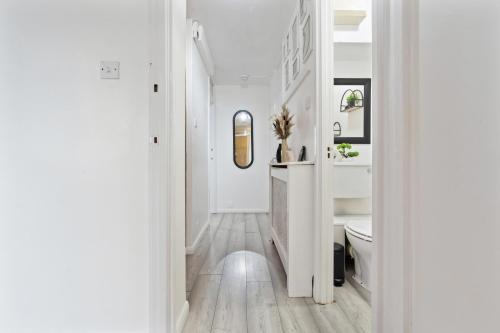 a white bathroom with a toilet and a sink at Modern 1-Bedroom Stockwell Apartment 15 mins to Central London - Perfect Base for Exploring London in London