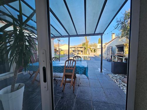 une porte en verre d'une terrasse avec une table et des chaises dans l'établissement belle maison beau cadre, à Bègles