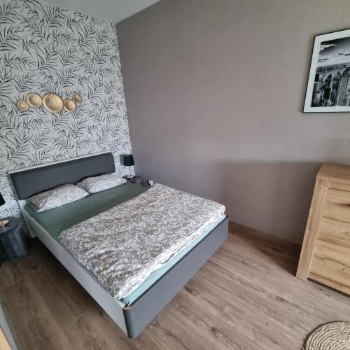 a bedroom with a bed and a wall at Apartament Sky in Leszno