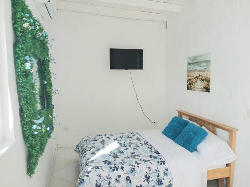a bedroom with a bed and a tv on the wall at Blue Ocean Apartment in Noord