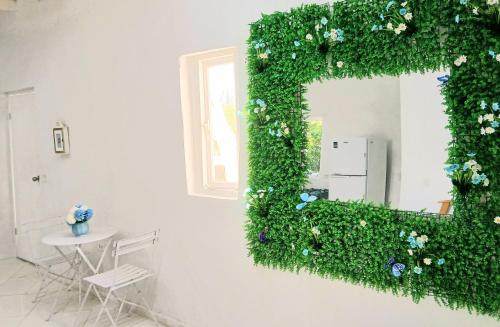 a mirror covered in green ivy on a wall at Blue Ocean Apartment in Noord