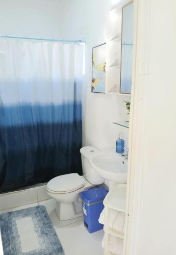 a white bathroom with a toilet and a sink at Blue Ocean Apartment in Noord