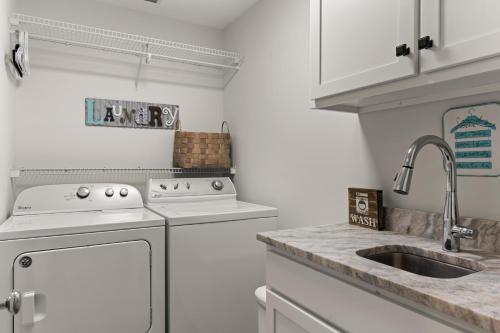 a kitchen with white appliances and a sink at Delahunt Cottage - 4218 Seventh Street in Saint Simons Island