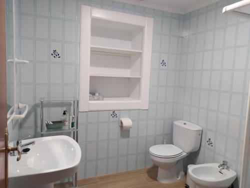 a bathroom with a white toilet and a sink at Casa Montilla in Granada
