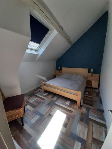 - une chambre mansardée avec un lit et une lucarne dans l'établissement Appart'Aléa, à Sablé-sur-Sarthe