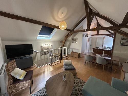 un salon avec une table et une télévision dans l'établissement Appart'Aléa, à Sablé-sur-Sarthe