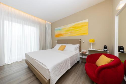 a bedroom with a bed and a red chair at Five by Capri 5 Senses in Anacapri