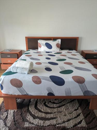 a bed with a colorful comforter in a bedroom at Leiria Tranquil Hideaway in Leiria