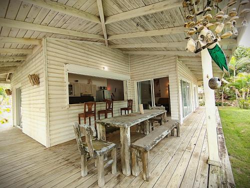 a wooden porch with a wooden table and chairs at Villa Bianca - BEACHFRONT with Pool in Sosúa