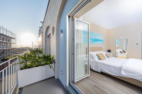 a bedroom with a bed and a balcony at Five by Capri 5 Senses in Anacapri