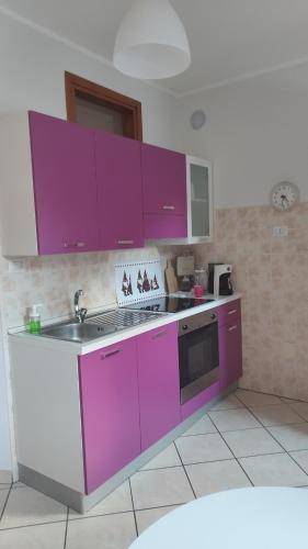 a kitchen with purple cabinets and a sink at Belvedere Di Simona Cotti Piccinelli in Bard