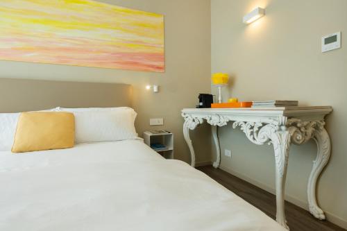 a bedroom with a white bed and a table at Five by Capri 5 Senses in Anacapri