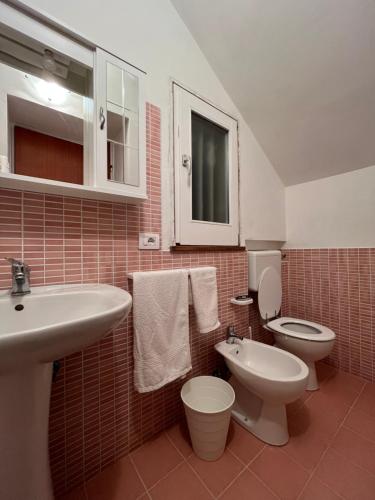 a bathroom with a white toilet and a sink at Clorofilla - Country House in Francavilla Angitola
