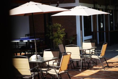 a group of tables and chairs with umbrellas at Le-Mao Chiang Dao in Chiang Dao