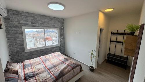 a bedroom with a bed and a brick wall at Sun Tower in Majdal Shams