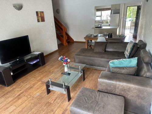 a living room with two couches and a tv at Paulshof Guesthouse - Monchique in Sandown