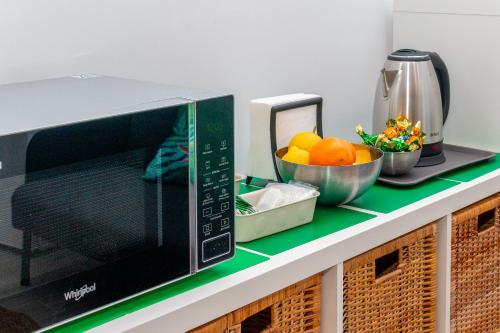 a microwave on a counter with a bowl of oranges at Moreno Rooms in Valencia