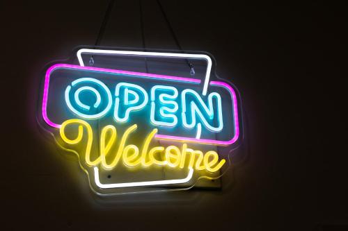 a neon sign that says open welcome in a neon sign at Moreno Rooms in Valencia