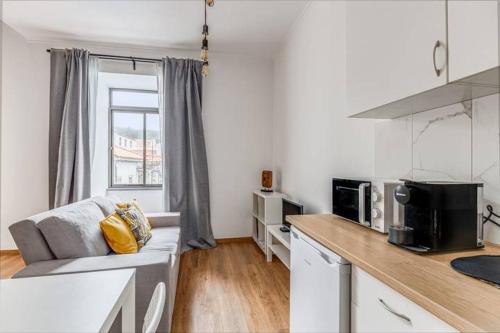 a living room with a couch and a kitchen at Apartamentos Casas da Travessa T0 T2 T3 in Horta