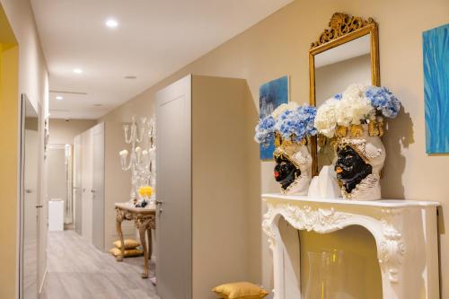 a hallway with a mirror and flowers on a shelf at Five by Capri 5 Senses in Anacapri