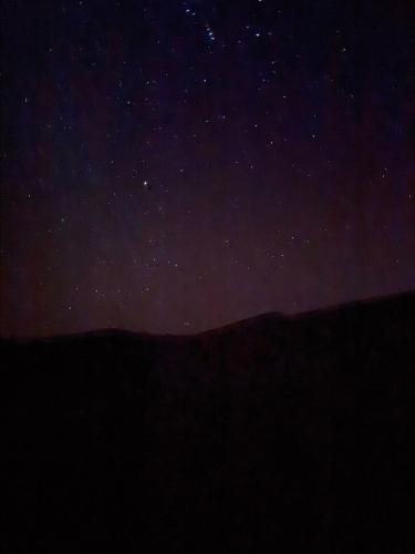 a starry night with the mountains in the background at Gambi Camp in Hassilabied