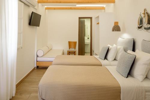 a room with two beds and a television in it at Karidis Hotel in Kamari