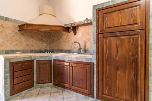 a kitchen with wooden cabinets and a sink at Le Villette di Villa Aurora in Lampedusa