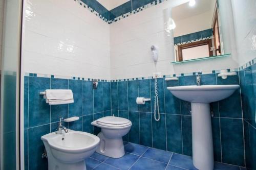 a blue and white bathroom with a toilet and a sink at Le Villette di Villa Aurora in Lampedusa