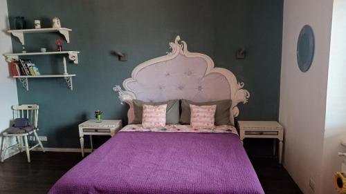 a bedroom with a purple bed with two tables at Lullaby Holiday in Trieste