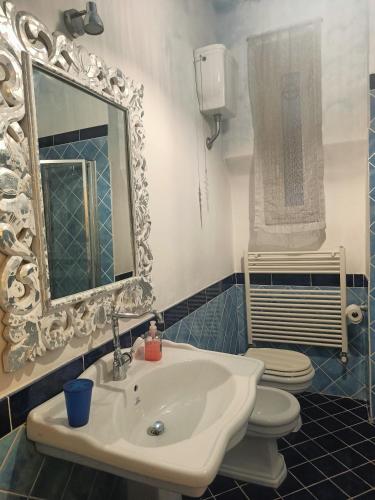 a bathroom with a sink and a toilet and a mirror at Lullaby Holiday in Trieste
