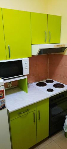 a kitchen with lime green cabinets and a stove at Apartman Mikica in Pančevo