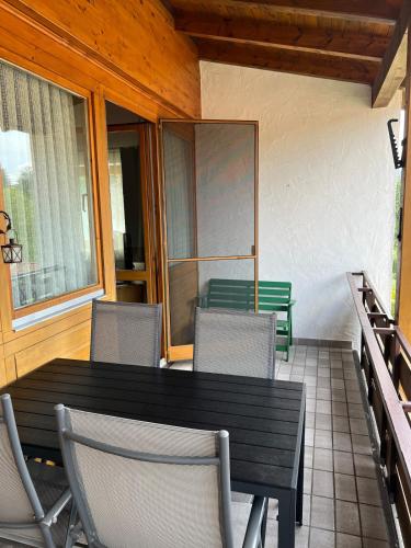 a wooden table and chairs on a porch with a table and chairs at Ferienwohnung Markt Eging am See Bayerischer Wald in Eging am See